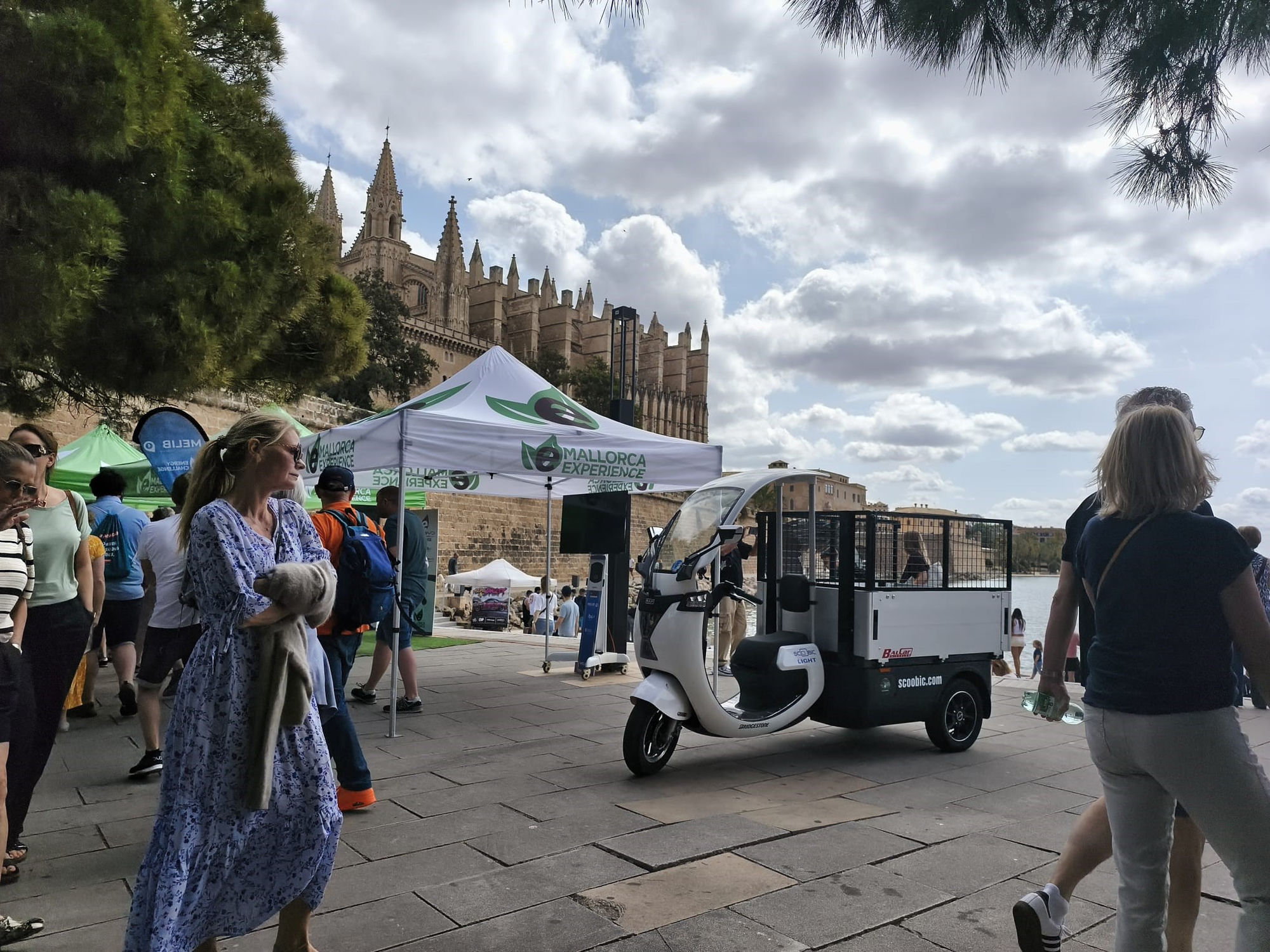 Un Scoobic Light eléctrico de reparto en el paseo del Parc de la Mar, con la Catedral de Palma al fondo, durante el eMallorca Experience